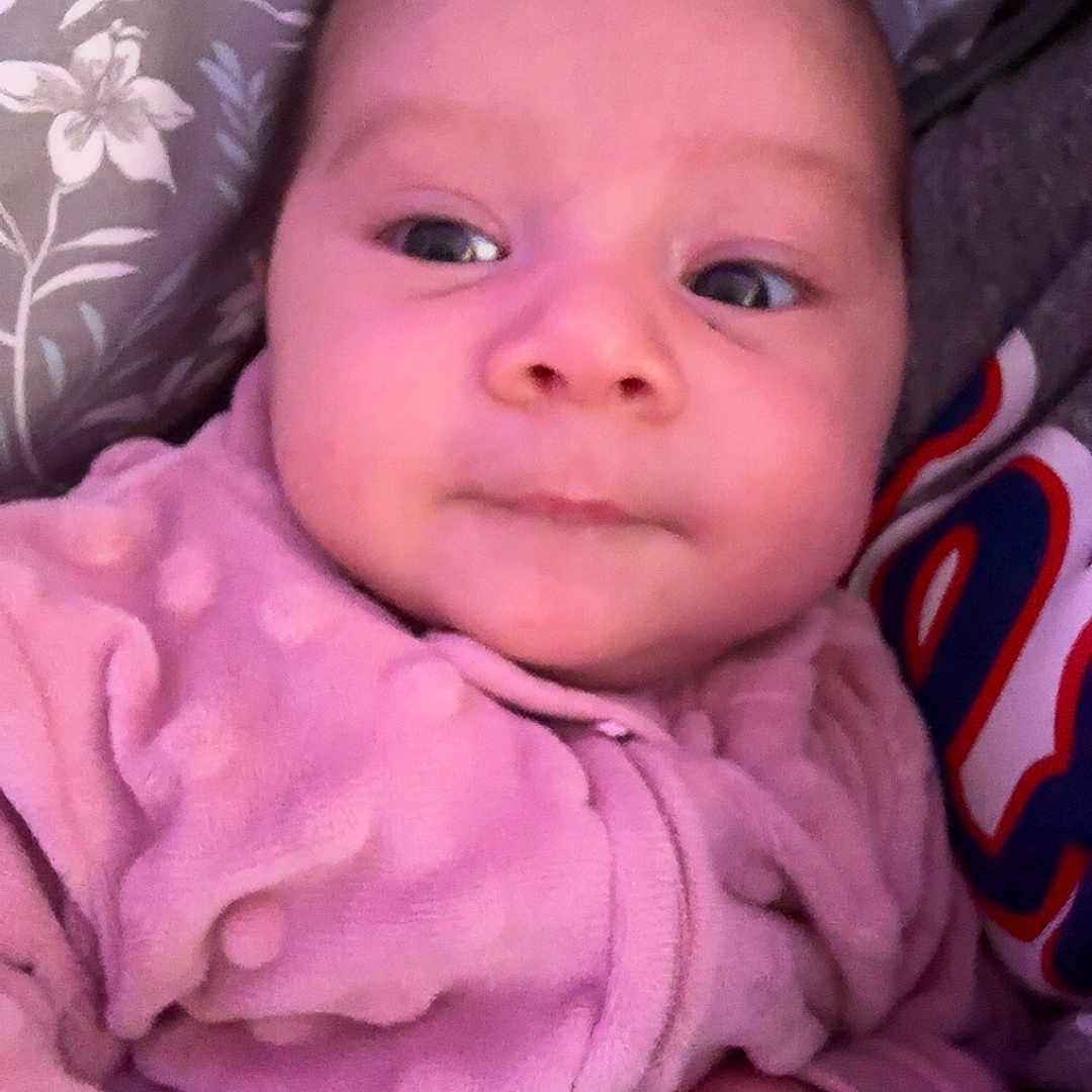 Taiina joined the competition — help win amazing prizes! baby, bird_pattern, child, closeup, cozy, curious_expression, cute, face, fist, floral_pattern, hand, indoor, infant, newborn, onesie, patterned_background, person, pink_clothing, portrait, soft_texture