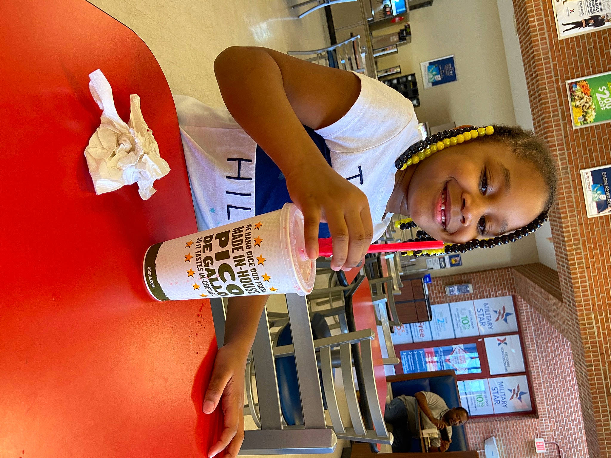 Christian is registered to the contest to win money with this photo: beer, chair, child, elbow, font, fun, happy, human_leg, joy, knee, leisure, person, room, shelf, smile, t_shirt, table, thigh, toddler, visual_arts