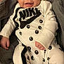 baby, infant, smiling, onesie, nike, clothing, blanket, gray, white, black, happy, face, portrait, cute, child, young, indoors, soft, comfortable, lying