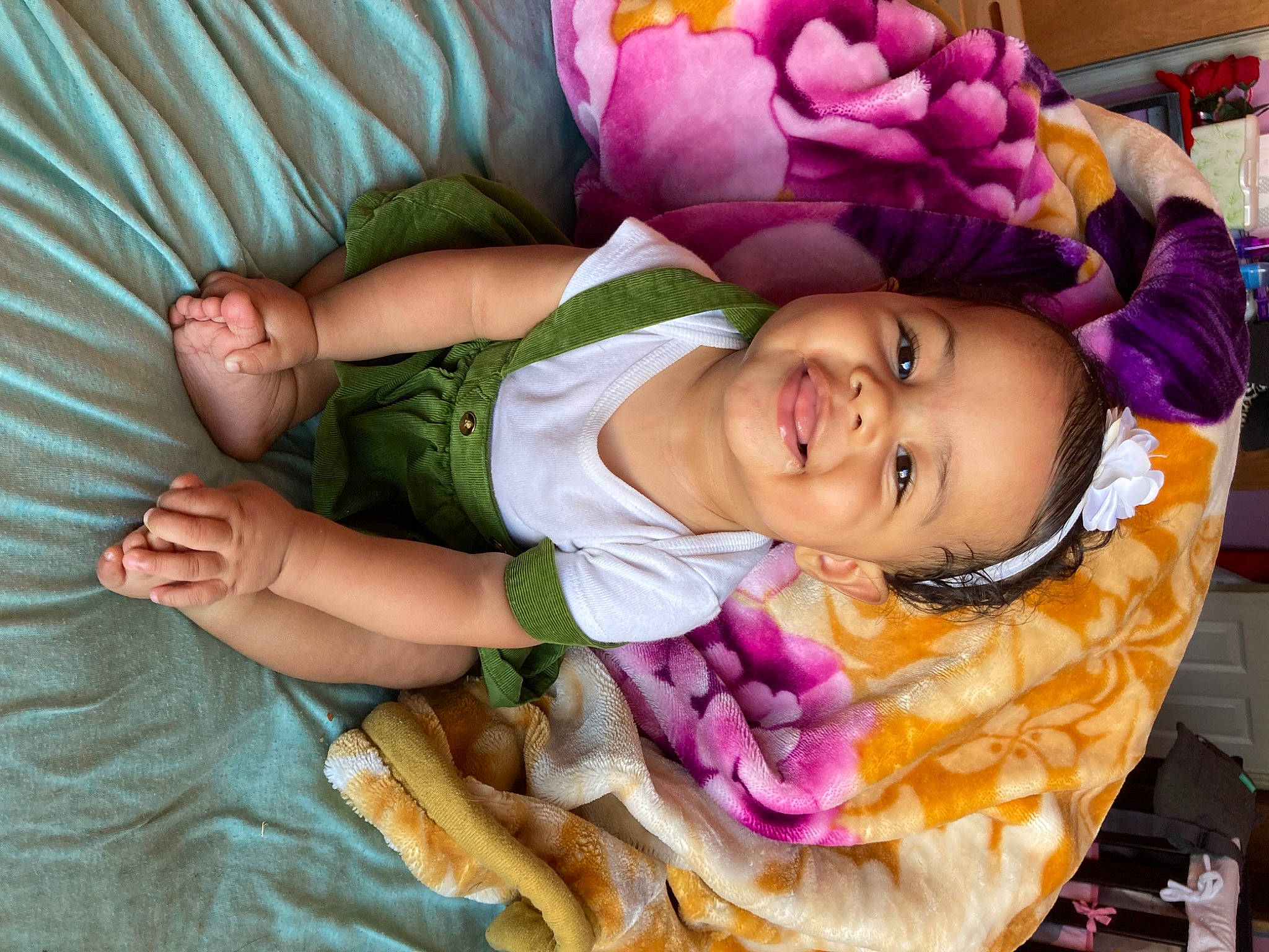 Zamara is registered to the contest to win money with this photo: arm, baby_toddler_clothing, cheek, comfort, eye, face, flower, fun, happy, head, human_body, iris, joy, mouth, person, pink, purple, skin, smile, toddler