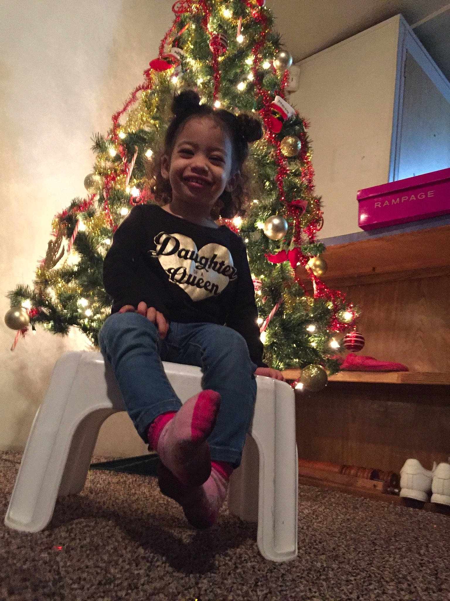 Samiyah is registered to the contest to win money with this photo: child, christmas, christmas_decoration, christmas_eve, christmas_ornament, christmas_tree, event, fir, fun, holiday, holiday_ornament, interior_design, joy, lap, person, pine_family, plant, sitting, smile, standing