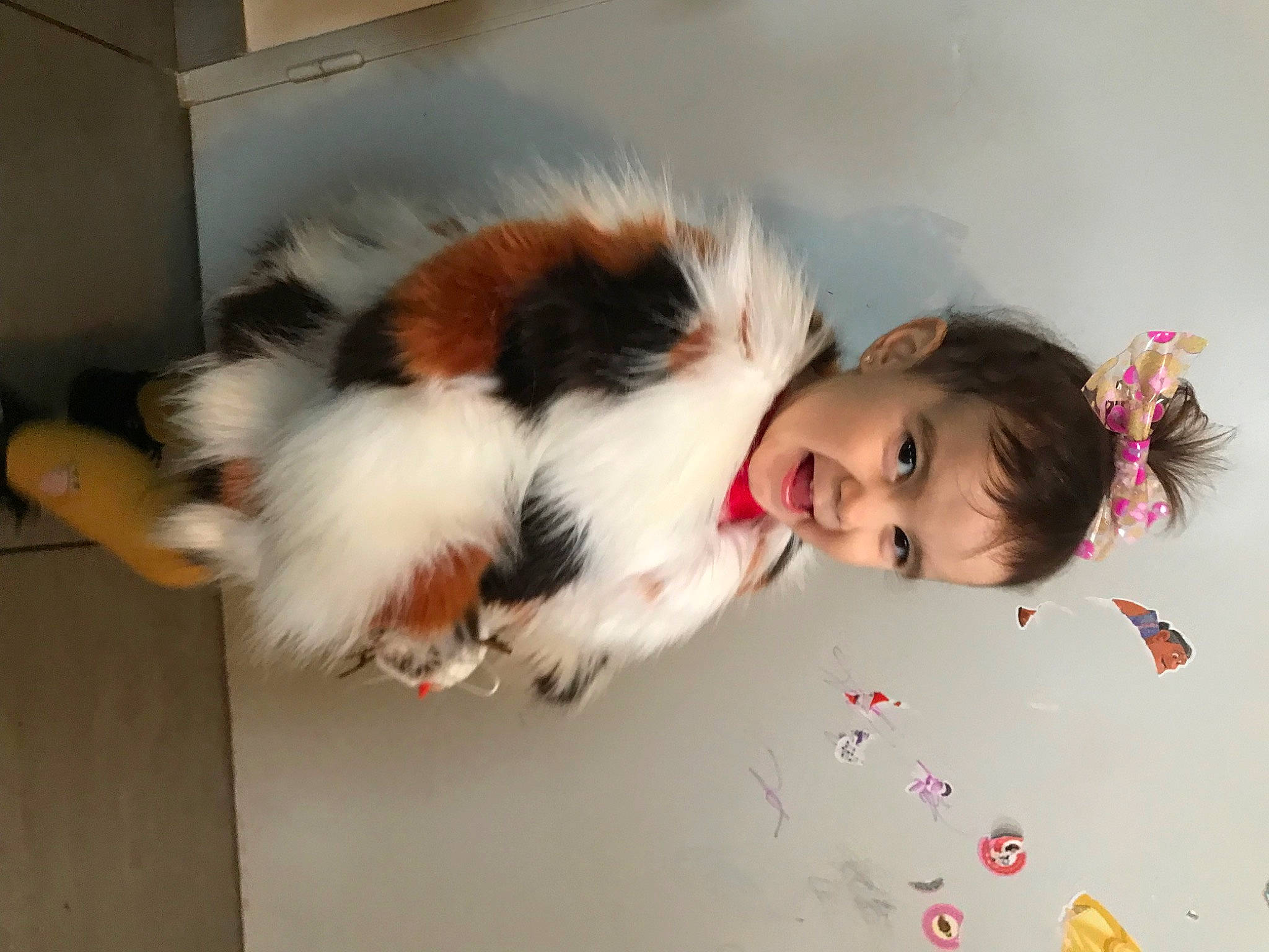 Kyra participe au concours pour gagner de l'argent avec cette photo : baby, bangs, child, companion_dog, costume, fun, fur, happy, natural_material, person, petal, portrait_photography, room, smile, tail, toddler