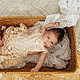 baby, infant, basket, lace_dress, blanket, woven, texture, soft, portrait, child, cute, resting, indoors, cozy, fabric, newborn, person, laying, looking, peaceful