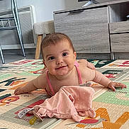Alba participe au concours pour gagner de l'argent avec cette photo : baby, child, colorful, cute, face, floor, furniture, happy, head, indoor, living_room, modern, pacifier_blanket, person, pink_outfit, play_mat, smiling, television, toy, wooden_leg