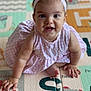baby, child, pink_dress, headband, crawling, play_mat, alphabet, indoor, happy, smiling, cute, infant, person, floor, hands, feet, young_child, portrait, closeup, colorful