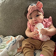 Rylea joined the competition — help win amazing prizes! baby, child, pink_bow, headband, couch, blanket, toy, socks, toddler, infant, clothing, cute, indoor, portrait, person, seated, soft_toy, happy, smile, home