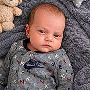 Camden joined the competition — help win amazing prizes! baby, infant, blanket, teddy_bear, plush_toy, gray, clothing, onesie, face, portrait, indoor, soft_texture, cute, child, sleepwear, pattern, logo, comfort, resting, young