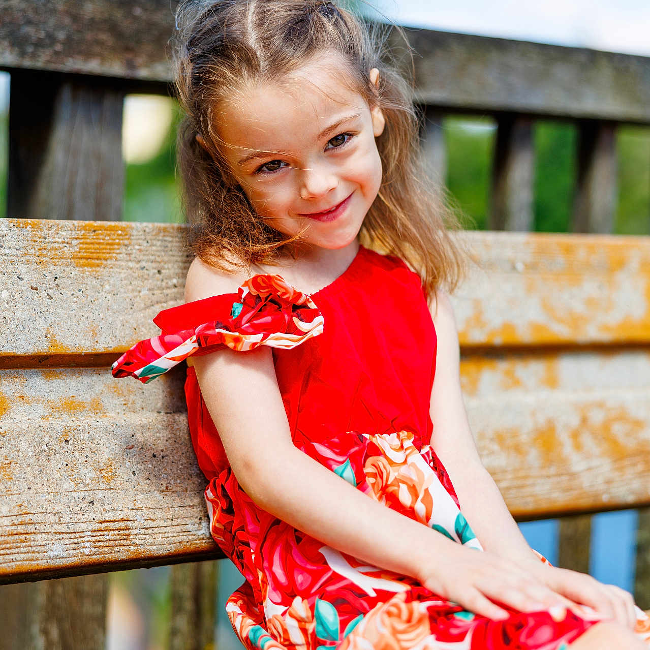 Kaytana participe au concours pour gagner de l'argent avec cette photo : background_blur, bench, casual_clothing, child, cute, daylight, flowers, girl, grass, happy, nature, outdoor, portrait, red_dress, sitting, smile, summer, sunlight, wood, young