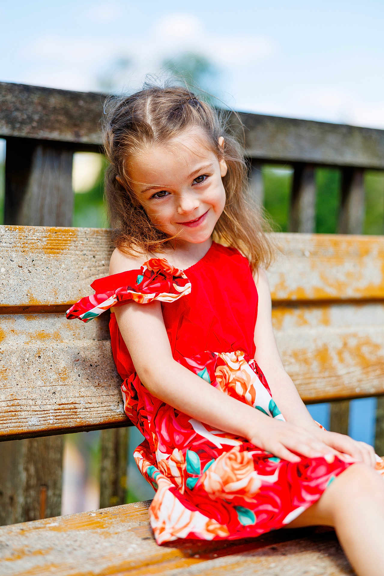 Kaytana participe au concours pour gagner de l'argent avec cette photo : child, girl, smile, red_dress, flowers, bench, wood, outdoor, sunlight, happy, portrait, nature, grass, summer, casual_clothing, sitting, young, cute, daylight, background_blur