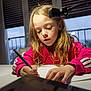 Kaytana participe au concours pour gagner de l'argent avec cette photo : child, girl, writing, drawing, table, desk_lamp, pink_jacket, long_hair, indoor, window, daylight, furniture, focus, concentration, person, hand, pen, paper, home, casual_clothing
