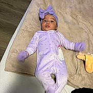 Ailany joined the competition — help win amazing prizes! baby, infant, child, portrait, lying_down, purple_outfit, headband, bow, mittens, blanket, plush_toy, bed, bedding, indoors, home, face, awake, cozy, floor, photography