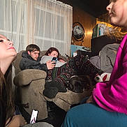 Holly joined the competition — help win amazing prizes! blanket, casual_clothing, child, cozy, curtains, dog, footrest, home, indoor, living_room, napping, patterned_pants, people, phone, recliner, relaxed, seated, technology, video_call, young_adult