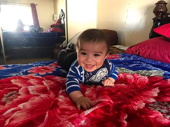 Isaias is registered to the contest to win money with this photo: baby, bed, bedding, bedroom, child, couch, furniture, home, joy, person, pink, play, red, room, textile, toddler
