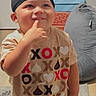 Lenox is registered to the contest to win money with this photo: baseball_cap, boxes, candid, casual, child, couch, face, finger_on_lips, happy, heart, home, indoor, kiss, love, portrait, rug, smiling, standing, t_shirt, toddler