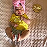 baby, bunny_print, child, cute, foot, grey_shorts, hand, happy, headwear, indoors, infant, lying_down, milestone, person, pink_bow, plaque, smiling, textured_blanket, three_months, yellow_shirt
