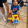 Kylo joined the competition — help win amazing prizes! toddler, child, toy_airplane, blue_shirt, pooh, indoor, floor_tiles, adult_hand, sneakers, stroller, yellow_toy, propeller, curious, person, footwear, child_playing, playtime, indoor_lighting, cute, small_person