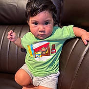 Kylo joined the competition — help win amazing prizes! toddler, child, person, face, brown_leather_couch, green_tshirt, shorts, indoor, sitting, cute, serious_expression, big_eyes, paul_frank, clothing, furniture, skin, hair, footwear_none, young_child, casual