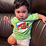 toddler, child, person, face, brown_leather_couch, green_tshirt, shorts, indoor, sitting, cute, serious_expression, big_eyes, paul_frank, clothing, furniture, skin, hair, footwear_none, young_child, casual
