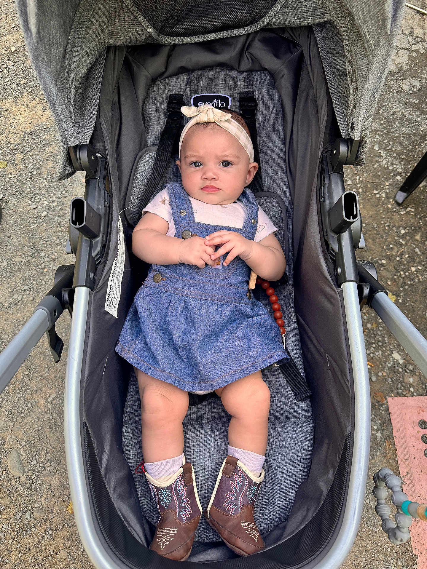 Georgia joined the competition — help win amazing prizes! baby, child, stroller, denim_dress, headband, bow, cowboy_boots, outdoor, gravel, curious, serious_expression, hands, clasped_hands, footwear, cute, infant, seat, baby_accessories, person, casual