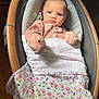 Georgia is registered to the contest to win money with this photo: baby, infant, blanket, floral_pattern, onesie, baby_rocker, wooden_frame, blue_eyes, indoor, flooring, pacifier, baby_clothing, portrait, child, newborn, cute, cozy, resting, wrapped, serious_expression