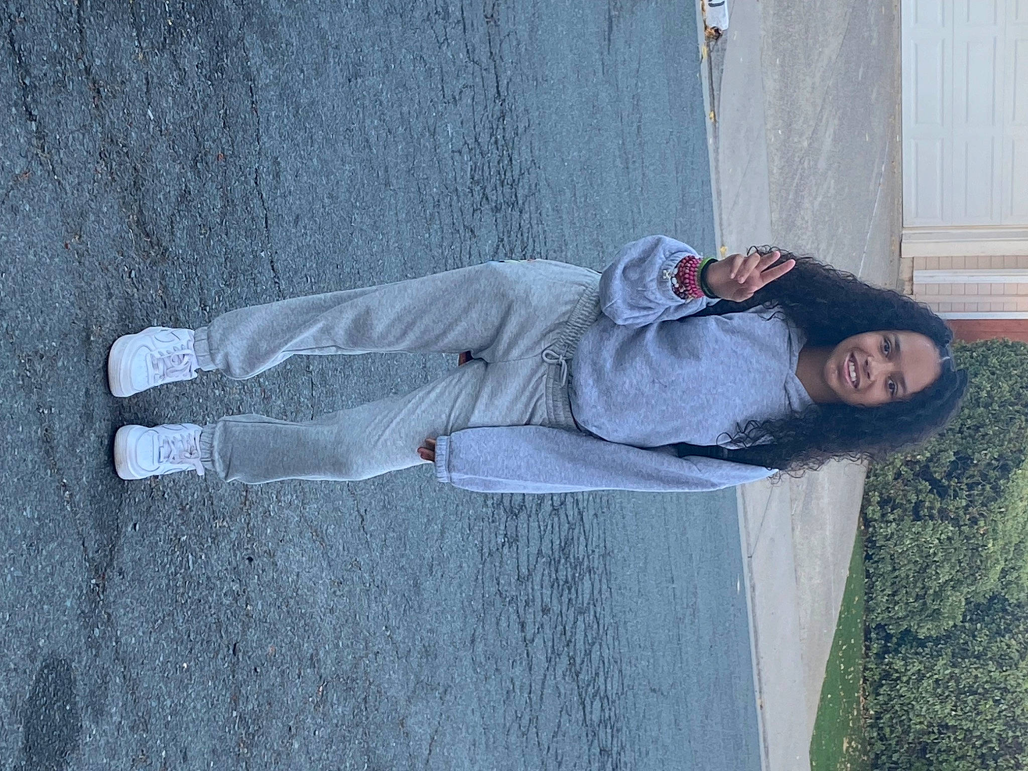 Jordyn is registered to the contest to win money with this photo: art, asphalt, concrete, denim, grass, grey, hat, joy, leisure, person, recreation, shadow, sidewalk, sitting, smile, walking_shoe, wall, water