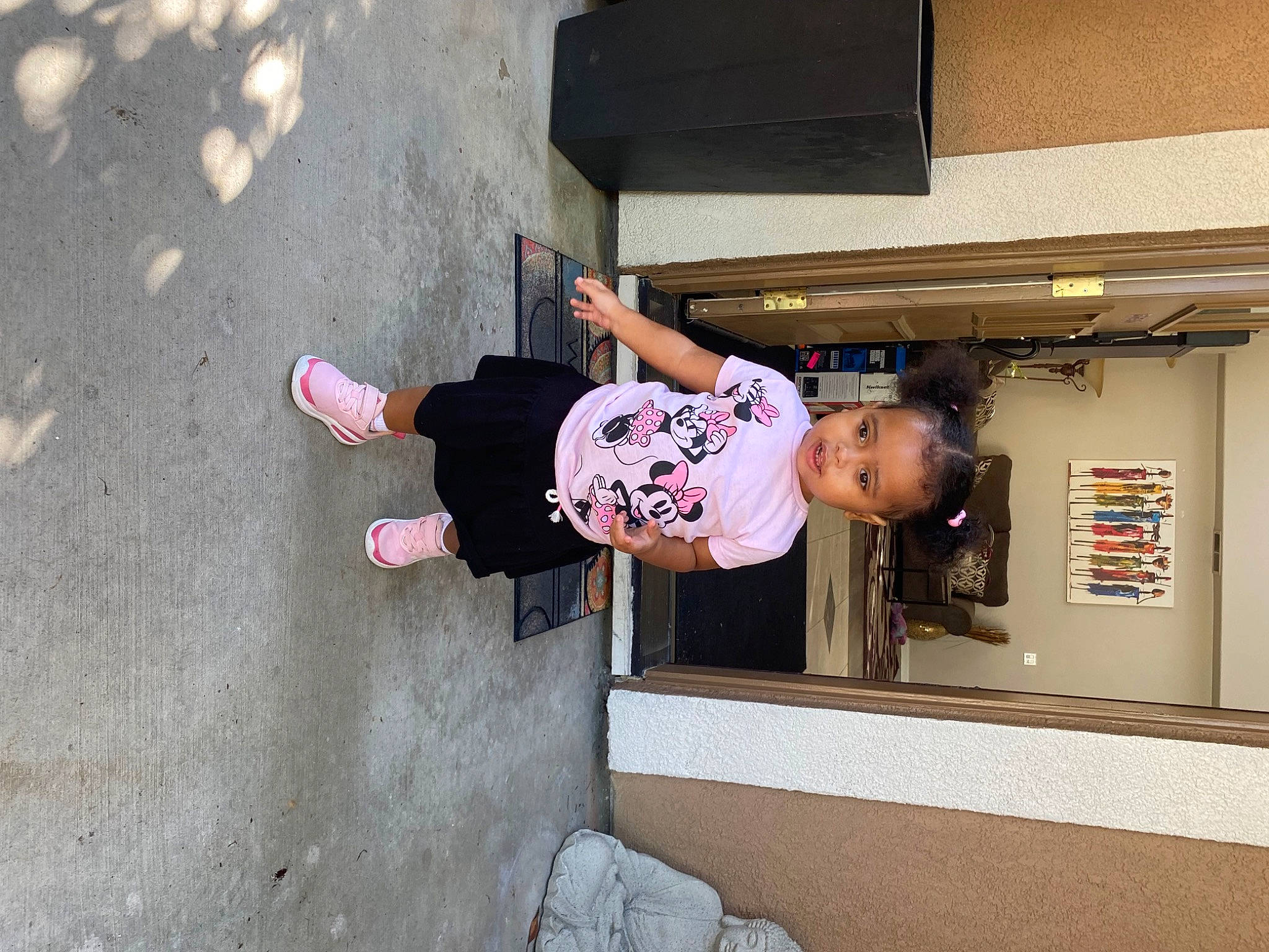 Justice is registered to the contest to win money with this photo: asphalt, child, composite_material, concrete, door, fun, house, outdoor_shoe, person, recreation, t_shirt, toddler, walking_shoe, window
