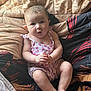 Isabelle is registered to the contest to win money with this photo: baby, infant, child, portrait, blanket, quilt, romper, pink, hands, feet, face, eyes, soft_light, indoors, cozy, cute, chubby, expression, hair, sitting