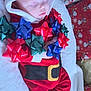 baby, sleeping, red_clothing, santa_outfit, holiday_bows, gift_bows, christmas, festive, wrapped_presents, blanket, face, infant, cute, holiday_decor, christmas_theme, toddler, cozy, indoors, child, holiday_season