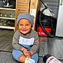 Reign is registered to the contest to win money with this photo: toddler, child, smiling, hat, socks, sitting, rug, floor, indoor, clothing, toy, vacuum, box, shelf, bottle, diet_coke, happy, cute, baby, home