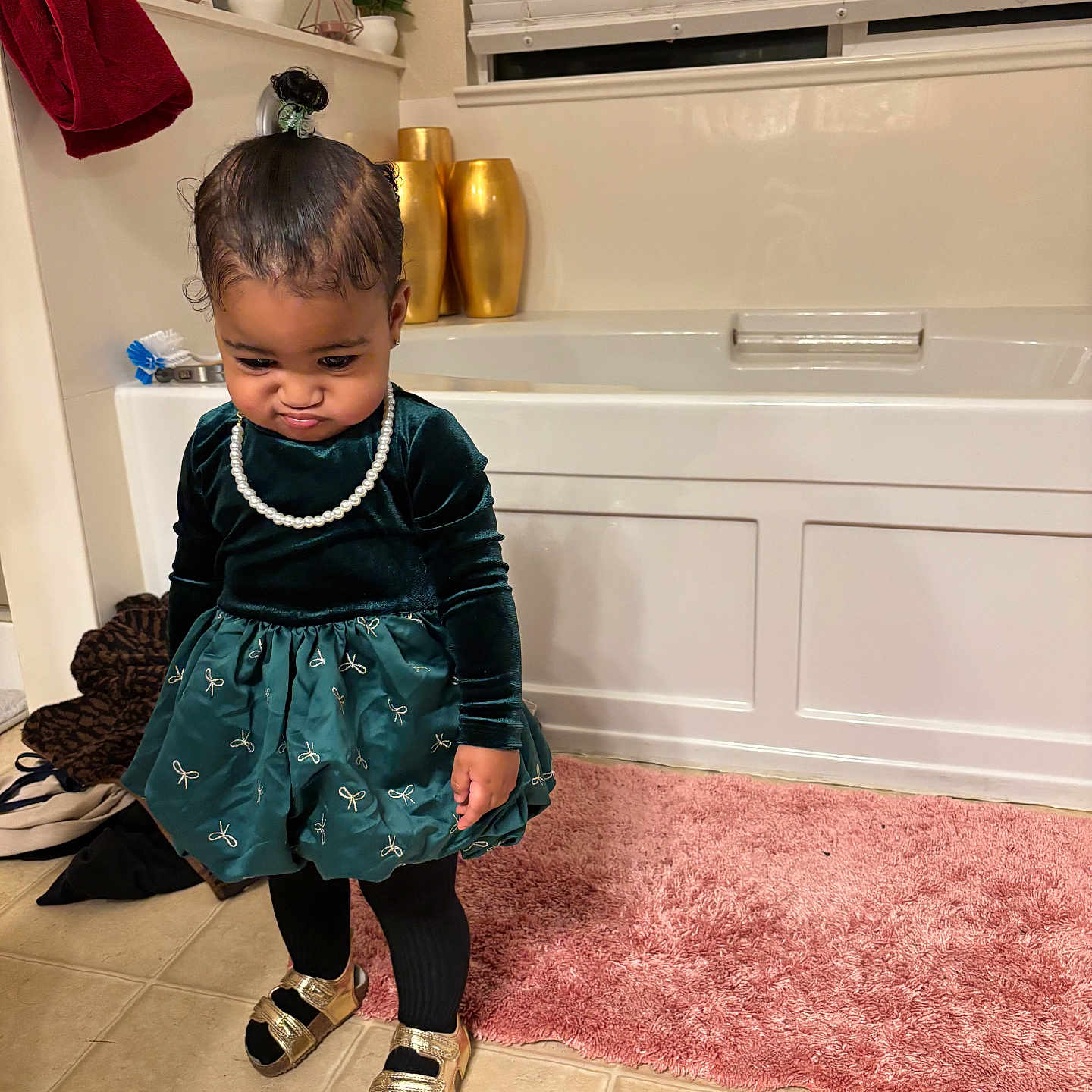 Brielle is registered to the contest to win money with this photo: toddler, child, bathroom, dress, pearl_necklace, pink_rug, gold_vases, plants, tiles, blinds, pout, black_tights, sandals, floor, indoor, curtains, home, person, cute, standing