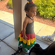 Brielle joined the competition — help win amazing prizes! toddler, child, dress, colorful_clothing, green_sneakers, outdoor, sidewalk, pillar, plants, sunny, curly_hair, casual, person, young_child, daylight, shoes, standing, curious, hair_tie, concrete
