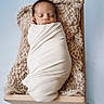 newborn, baby, swaddled, sleeping, blanket, wooden_bed, knit, cozy, soft, infant, portrait, peaceful, wrapped, child, resting, cute, studio, photography, blue_background, toddler