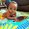 Kanan is registered to the contest to win money with this photo: baby, infant, child, portrait, wide_eyes, indoors, play_mat, colorful, toys, mirror, crawling, tummy_time, sitting, brown_sofa, living_room, hands, curly_hair, playtime, cozy, photography