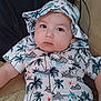 baby, infant, child, tropical_print, hat, sunglasses, cushion, clothing, portrait, indoors, cute, chubby_cheeks, relaxed, face, person, young_child, fashion, seated, looking_at_camera, casual