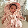 Isla is registered to the contest to win money with this photo: baby, infant, pink_robe, fluffy, hooded, bed, blanket, cute, soft, newborn, sleepwear, child, portrait, indoors, resting, small_hands, expression, cozy, toddler, wearing