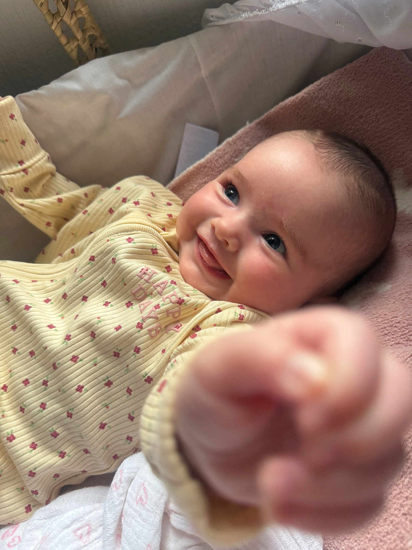 Isla is registered to the contest to win money with this photo: baby, smiling, infant, yellow_clothing, reaching_hand, cute, happy, face, blue_eyes, soft_blanket, lying_down, indoor, child, closeup, playful, skin, newborn, person, apparel, expression