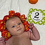 2_months, autumn, baby, blanket, celebration, child, close_up, cute, eyes, face, flower_crown, infant, lying_down, milestone_card, portrait, pumpkins, red_bracelet, roses, skin, smiling
