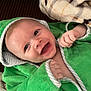 Toby is registered to the contest to win money with this photo: baby, blanket, child, comfort, couch, cozy, cute, expression, face, furniture, green_towel, happy, hooded_towel, indoor, infant, joy, portrait, skin, small_hands, smiling