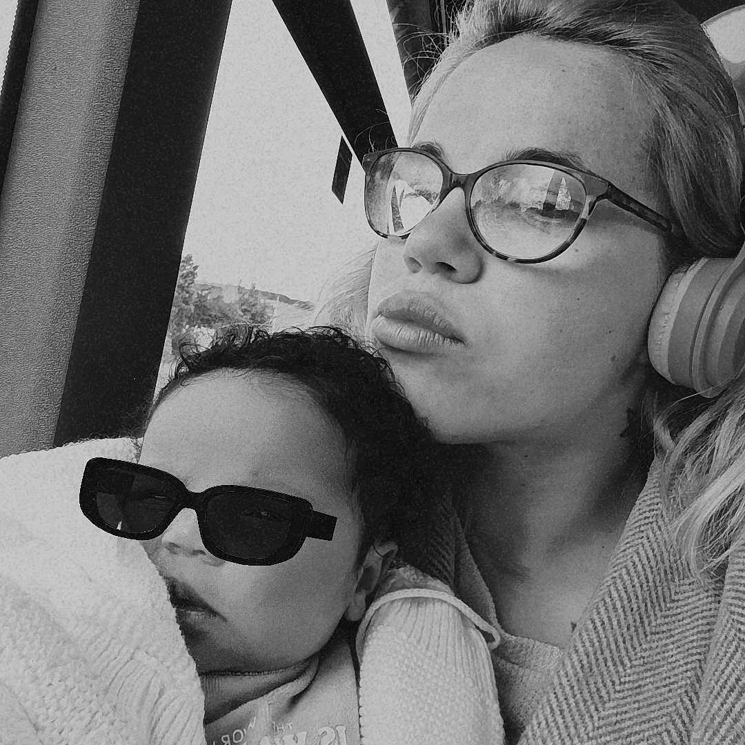 Lee-Nayä participe au concours pour gagner de l'argent avec cette photo : baby, black_and_white, blanket, bus, child, closeup, clothing, cozy, family, glasses, headphones, indoor, person, portrait, reflection, seated, sunglasses, travel, window, woman