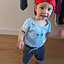 background_clothes, blue_shirt, casual_wear, child, clothing, cute, face, happy, home, indoor, motion_blur, person, playful, red_cap, sandals, shorts, smiling, toddler, wooden_floor, young_child
