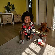 Messiah joined the competition — help win amazing prizes! afro, baby_socks, carpet, child, cozy, drawers, furniture, happy, home, indoor, plant, potted_plant, robe, room, shadow, smiling, sunlight, teddy_bear, toddler, wooden_floor