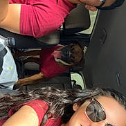 Atlas is registered to the contest to win money with this photo: car_interior, people, man, woman, dog, dog_in_sweater, red_clothing, sunglasses, smiling, seatbelt, happy, tongue_out, long_hair, casual, road_trip, pet, window, daylight, friendship, travel