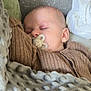 baby, blanket, brown_sweater, child, closeup, comfort, cozy, cute, face, head, indoor, infant, pacifier, peaceful, portrait, relaxation, resting, sleeping, soft_texture, warm