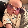 baby, sleeping, sunglasses, onesie, bear_print, blanket, cozy, cute, infant, hand, face, head, soft_texture, closeup, indoors, comfort, rest, peaceful, cute_outfit, accessory