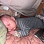 baby, sleeping, blanket, pacifier, stuffed_animal, soft_toys, onesie, quilted_blanket, indoor, child, peaceful, resting, cute, cozy, infant, hand, face, head, pajamas, nap