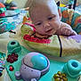 baby, child, closeup, colorful, curious, expression, face, floor, furniture, hand, head, indoor, infant, padded, pattern, person, play_station, room, smiling, toy