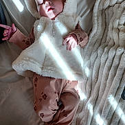 Maja is registered to the contest to win money with this photo: baby, bed, blanket, child, comfort, cozy, fabric, face, foot, hand, hooded_vest, indoor, infant, pajamas, paw_prints, peaceful, resting, sleeping, soft_light, texture