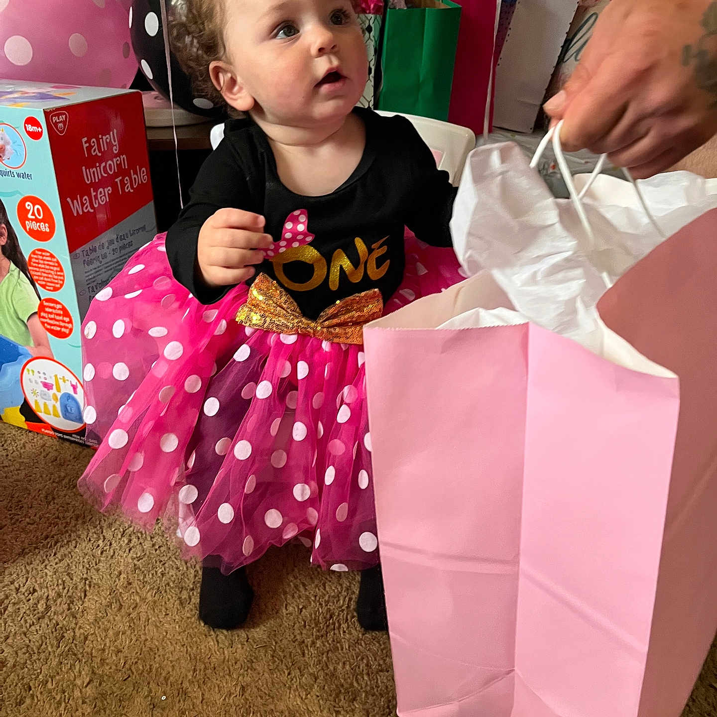Miracle is registered to the contest to win money with this photo: baby, balloons, birthday, carpet, celebration, child, clothing, curly_hair, dress, face, gift_bags, hand, indoor, party, person, pink, polka_dot, shoe, tattoo, tutu