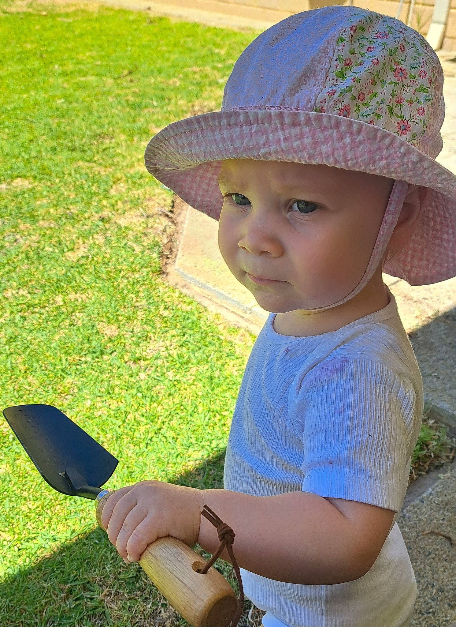 Harlow is registered to the contest to win money with this photo: baby, baby_toddler_clothing, cap, fun, grass, grass_family, green, happy, hat, headwear, leaf, light, mobile_phone, people_in_nature, person, photograph, plant, snapshot, summer, sun_hat