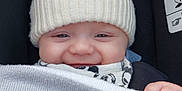 Jaxson is registered to the contest to win money with this photo: baby, beanie, blanket, bodypart, bonnet, cap, car, car_interior, carseat, clothing, couch, face, finger, furniture, glove, hand, happy, hat, head, hood